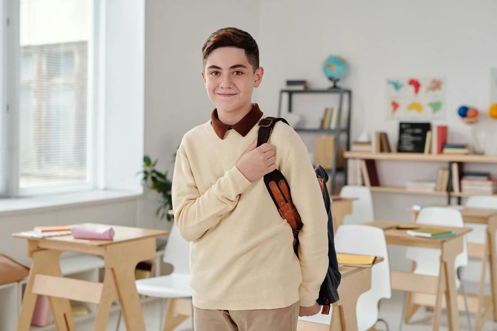 A student stands with a backpack on, ready for school